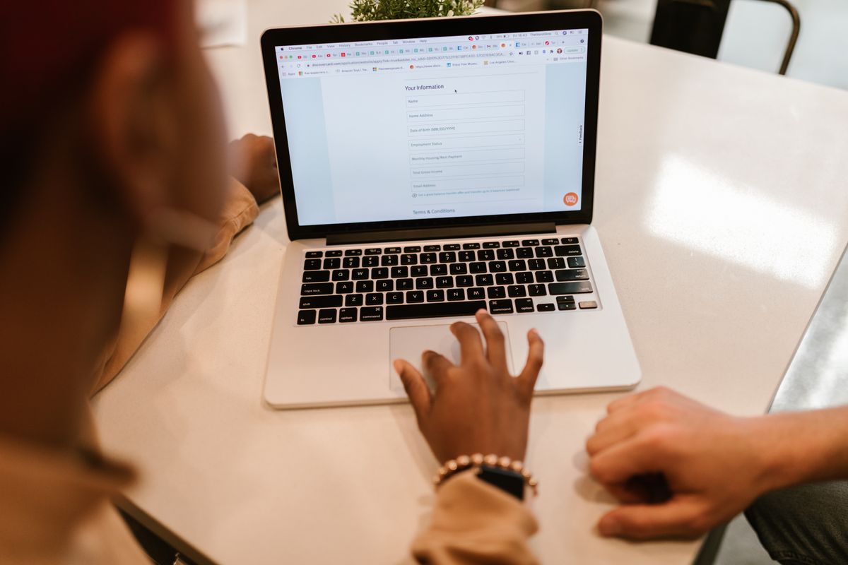 Dwie osoby sprawdzają formularz na ekranie laptopa. Fot. RDNE Stock project / Pexels.