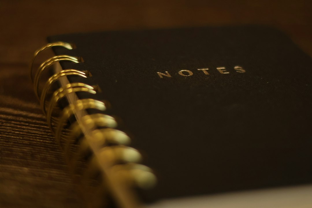 Czarny notes ze złotą spiralą symbolizujący historię marki