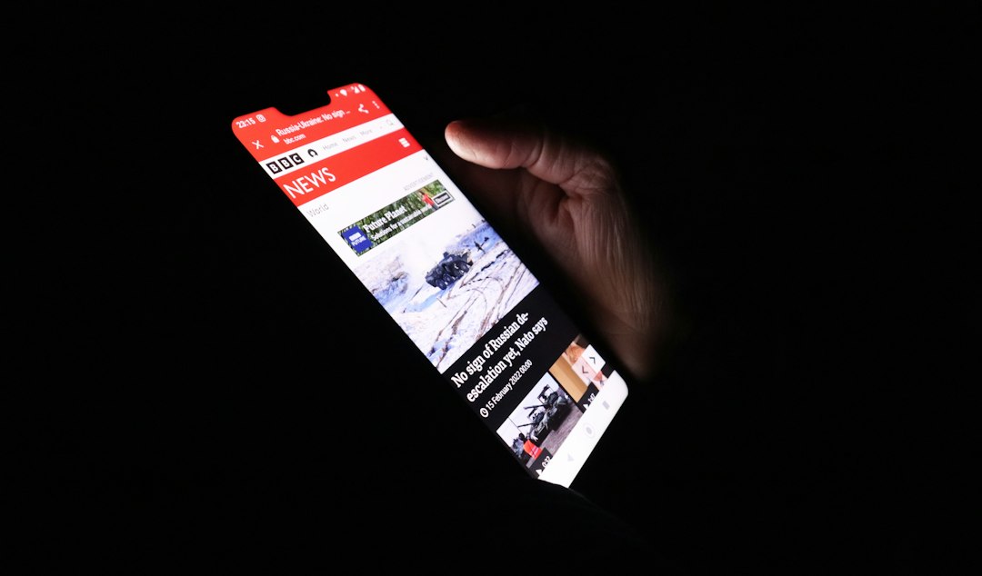 Osoba korzystająca ze strony internetowej na smartfonie w ciemnym otoczeniu